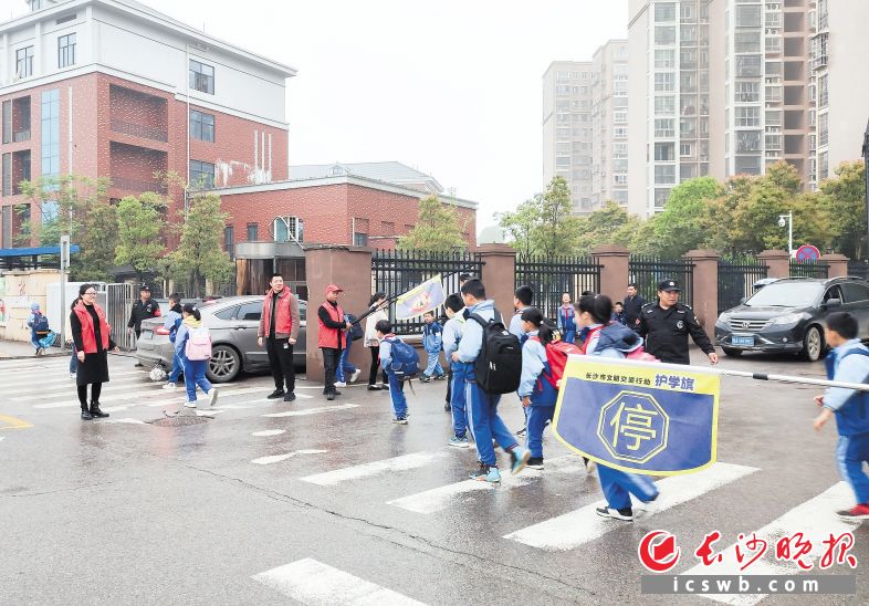 4月7日,长沙高新区雷锋街道党员干部化身红马甲志愿者,护送学生过马路。受访者供图 4月7日,长沙高新区雷锋街道党员干部化身红马甲志愿者,护送学生过马路。受访者供图