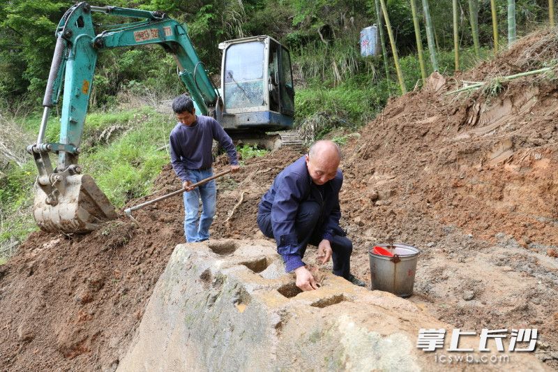 4月23日，潭湾村发现疑似红军时期造币设施，村民清洗巨石上方的几个小槽。长沙晚报全媒体记者 颜开云 摄