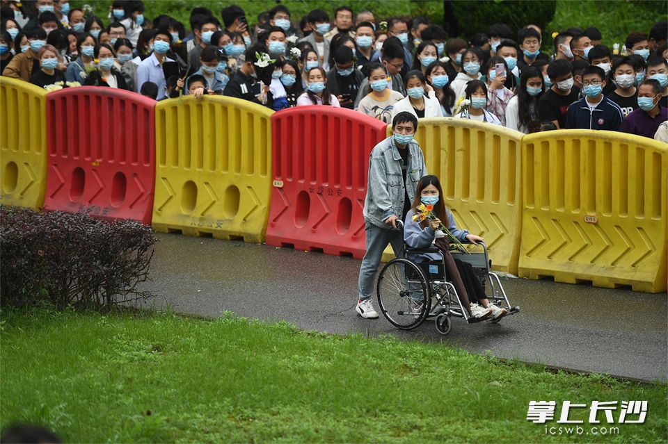 5月23日，一位坐着轮椅的女生被推着进入殡仪馆缅怀袁老。
