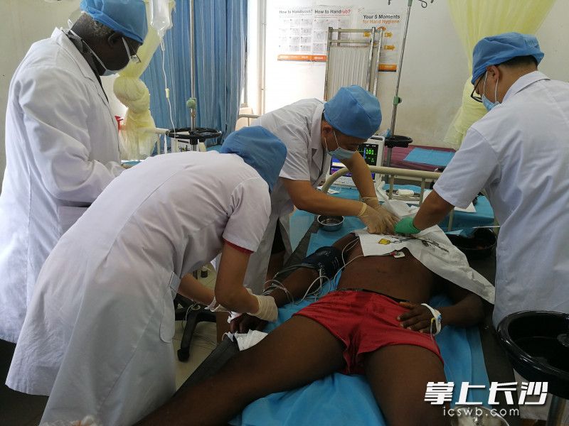 援塞医疗队员、中南大学湘雅医院急诊科副教授粟枫、骨科副教授刘华，中南大学湘雅二医院主管护师卢盛正在抢救塞拉利昂受伤男子。