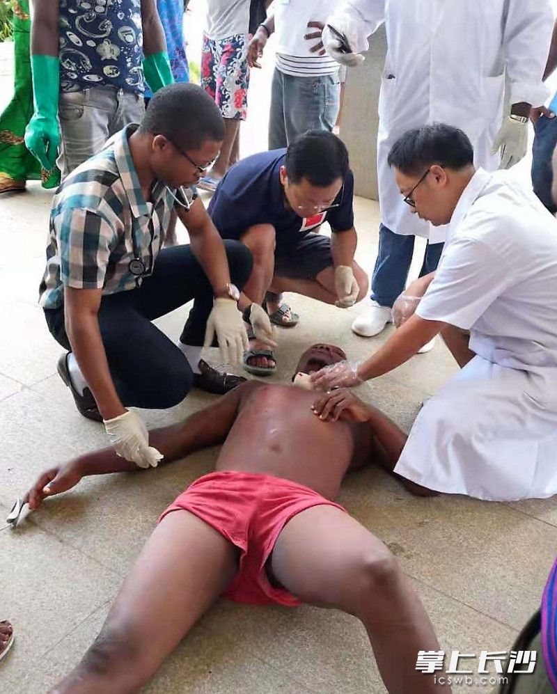 援塞医疗队队长江海波（中）和队员粟枫（右）在第一时间赶到伤者身边，并为其进行伤情检查评估。照片由援塞医疗队员杨卉 摄