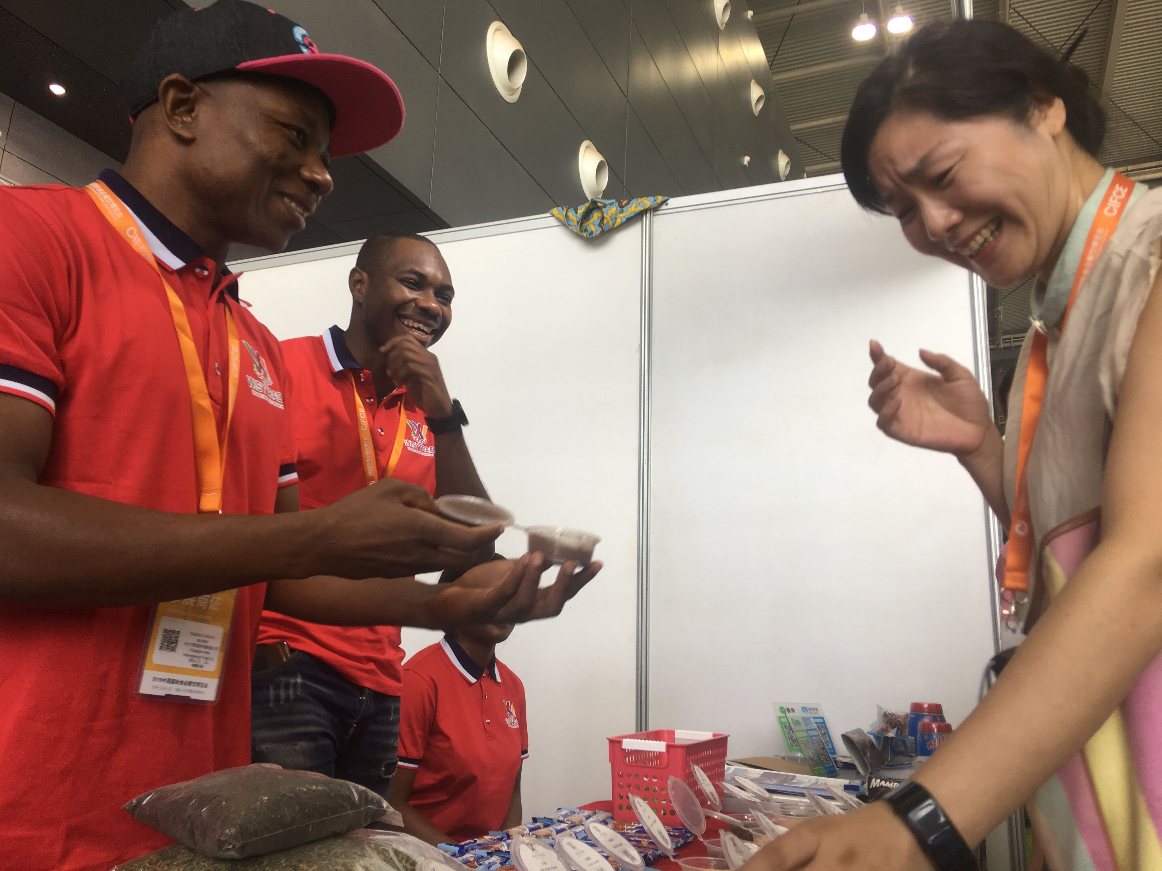 夏天（左二）在向顾客介绍自己家乡的产品。周辉霞摄 