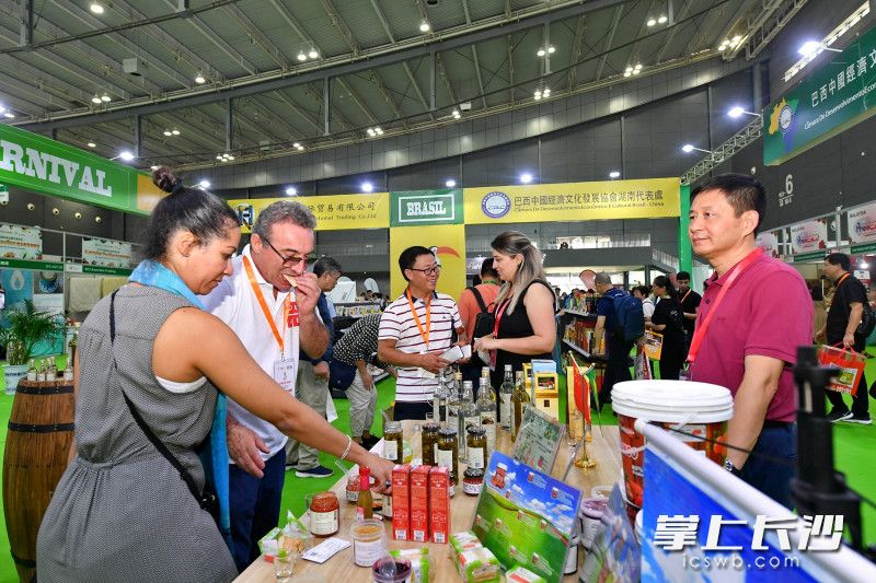 图为观展商在品尝选购商品。长沙晚报全媒体记者 王志伟 摄