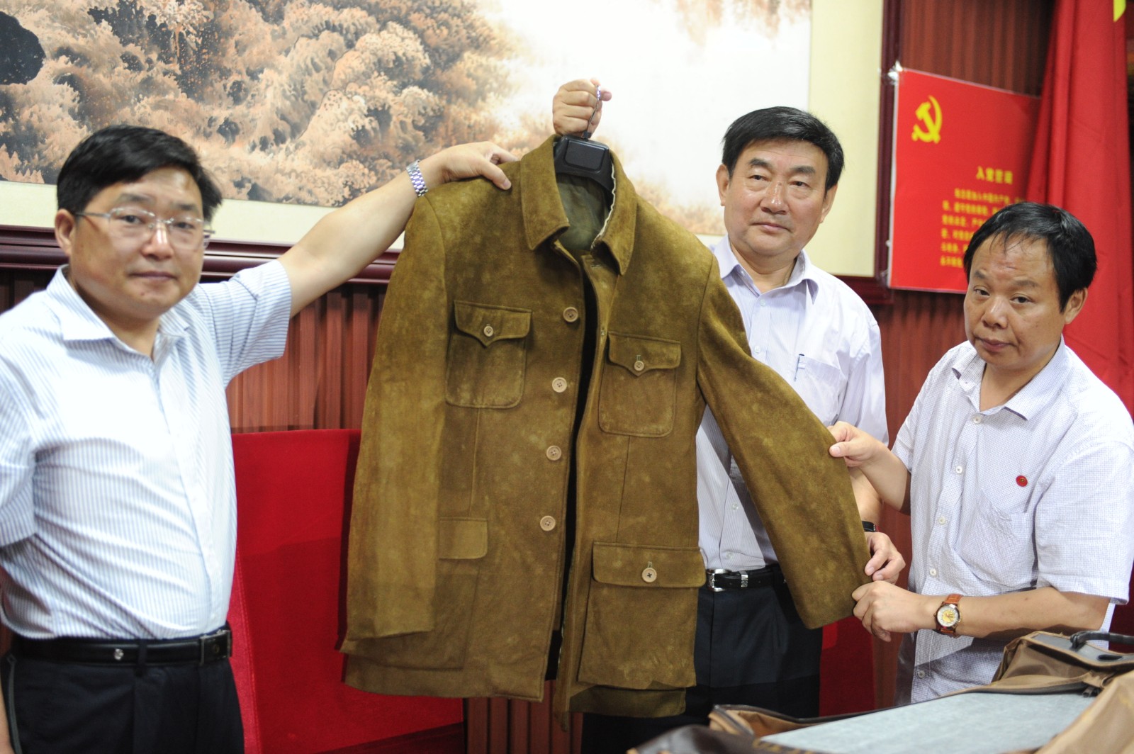 2014年7月14日，毛主席的卫士长李银桥之子李卓韦（右二）专程来到长沙，将毛主席穿过的一套中山装礼服捐献给了湖南红色档案馆。长沙晚报全媒体记者 贺文兵 摄