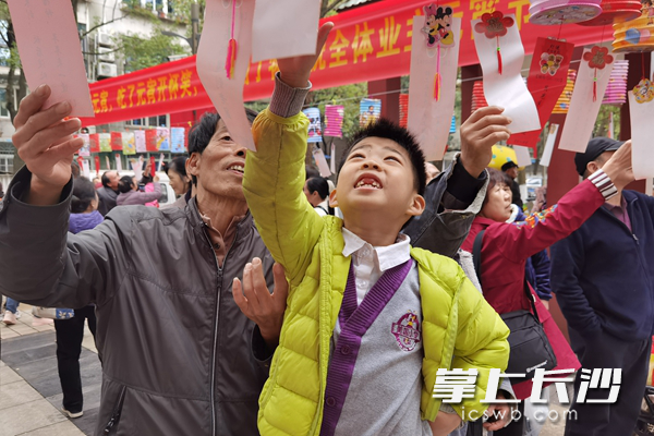 居民们兴致勃勃猜灯谜。