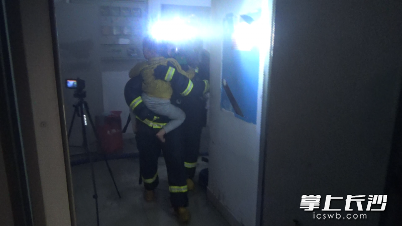消防员从火场中将被困的亮亮救出。视频截图