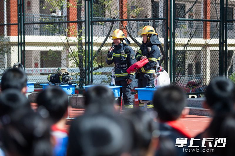 现场，消防员为同学们介绍常用的灭火救援器材。