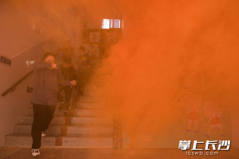 在演练现场，同学们用湿毛巾捂住口鼻，有序进行疏散。均为长沙晚报全媒体记者 黄启晴 摄