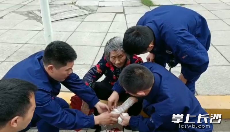 消防员为老人包扎伤口。视频截图