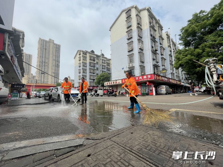 环卫清扫保洁员将路面沉积的泥沙冲洗干净。  均为长沙晚报全媒体记者唐朝昭摄