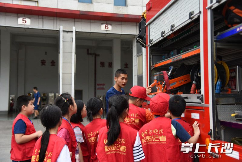 6月20日，来自枫树山小学、东郡小学、开福区第一小学等学校近500名长沙晚报小记者走进雷锋消防救援站。图为消防员向大家介绍各类消防车辆及车上消防装备的用途。均为长沙晚报全媒体记者 刘琦 摄