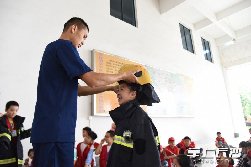 消防员为大家讲解无齿锯等消防器材的功能，并带大家体验穿灭火防护服。