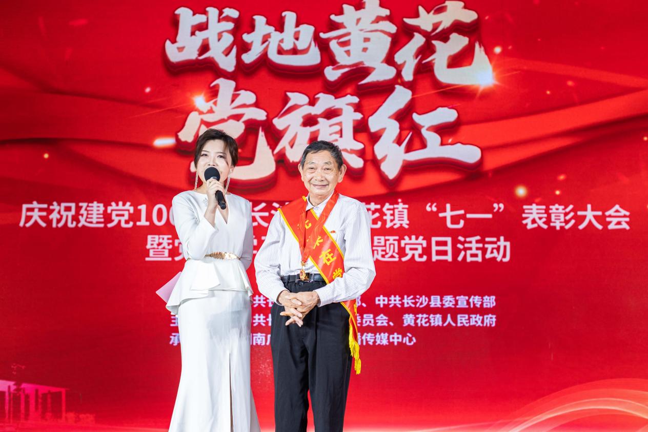 主持人在现场采访老党员代表王再德