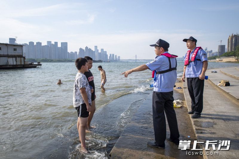 水警对岸边的未成年人进行安全教育。
