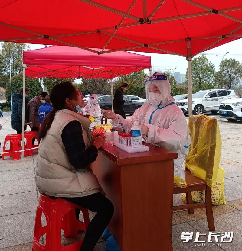 易会春在进行核酸检测采样。通讯员 供图