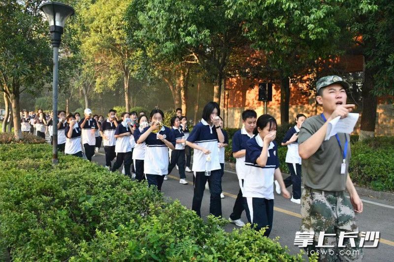 演练中，学生们用湿毛巾捂住口鼻，向安全地带撤离。