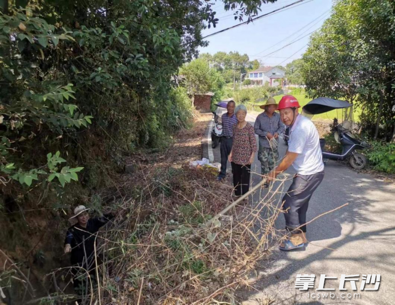 志愿者主动对渠道进行维修疏通，确保水源能及时输送到农田。  均为长沙晚报通讯员谭笑摄