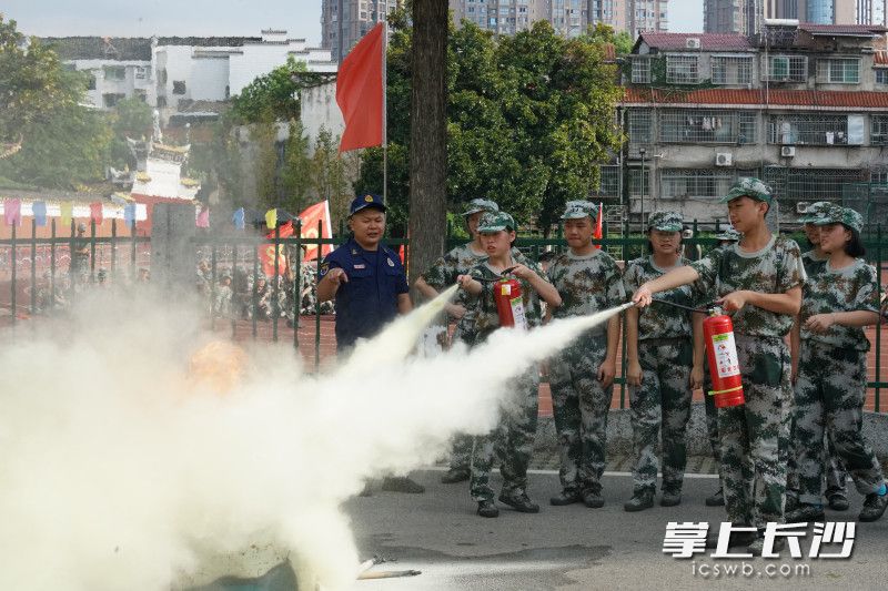 在浏阳市第一中学，“火焰蓝”教正在军训的学生使用干粉灭火器。长沙晚报通讯员 寻艳 供图