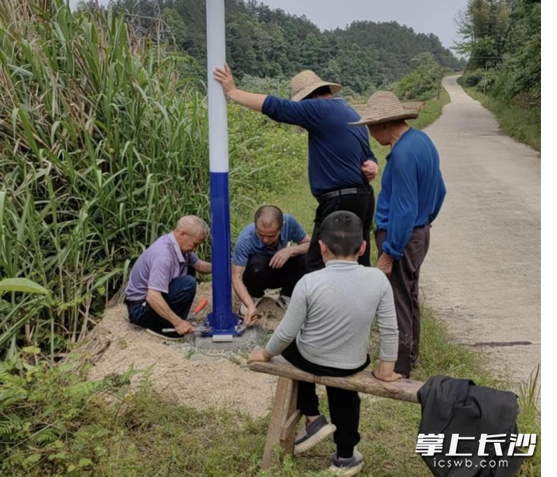 灰汤镇双建村西冲组村民代表带领群众一起安装路灯。