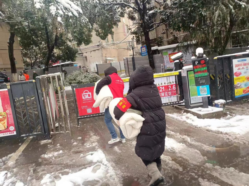 志愿者为独居老人送棉被。