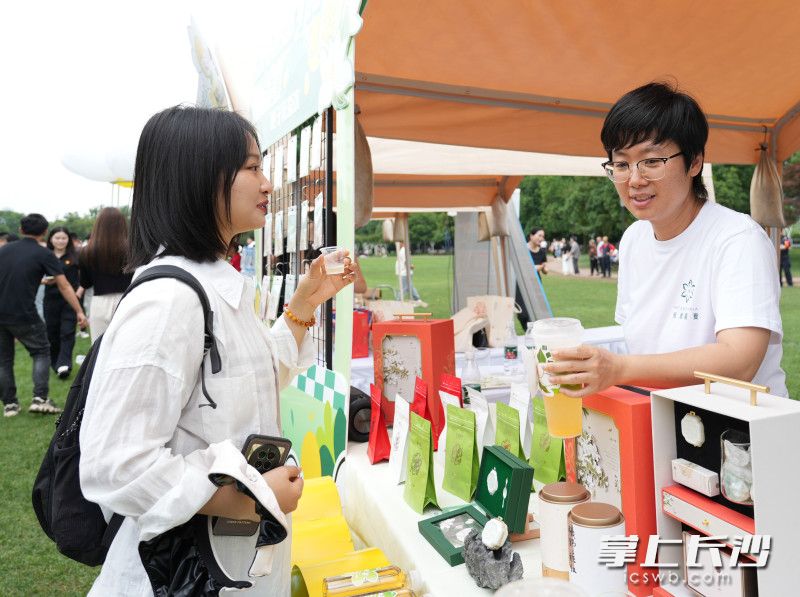 一位市民正在体验栀子花茶饮新品。
