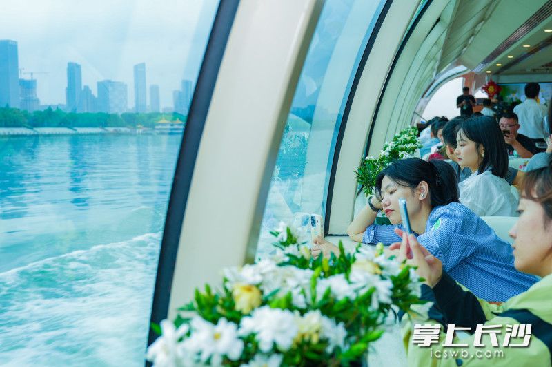 “栀香长沙”号游轮正式起航，游船上花香四溢，游客们正在打卡拍照。
