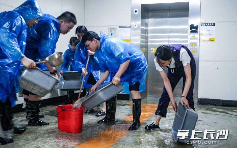 地铁工作人员正在清理地铁站通道积水。