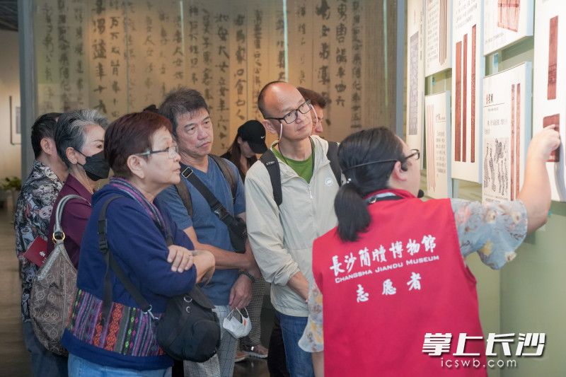 一位志愿者正在为观众讲解《承汉启唐——北朝书法与雕塑艺术展》展品。