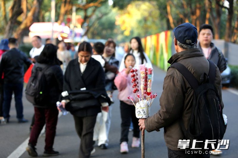 一小贩在站在步道中央叫卖冰糖葫芦。 均为长沙晚报全媒体记者贺文兵摄