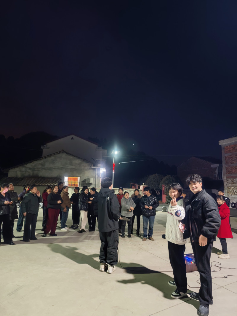 广西师大学生夜晚来到璜塘湾广场，自弹自唱，吸引村民围观。