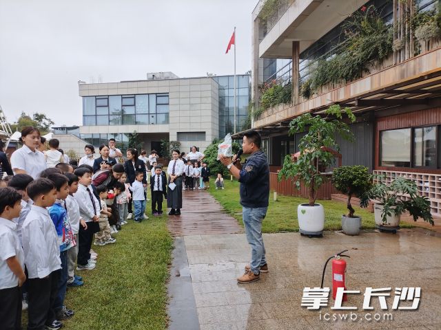 万教官现场演示防毒面具与灭火器的正确使用方法。