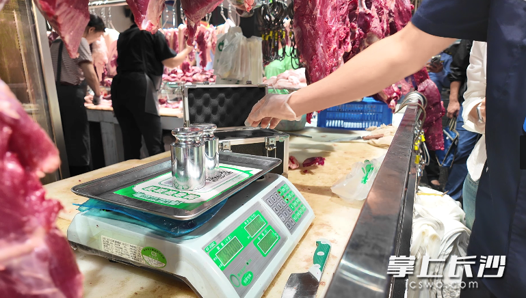 检定人员正用砝码检查秤具准确情况。长沙晚报全媒体记者 周辉霞 摄