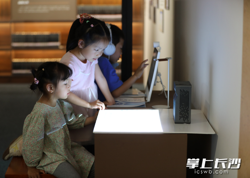 中小学生读者在长沙图书馆二楼展厅“书承文脉远 家国湖湘情”文献特展参与数字互动。 中小学生读者在长沙图书馆二楼展厅“书承文脉远 家国湖湘情”文献特展参与数字互动。