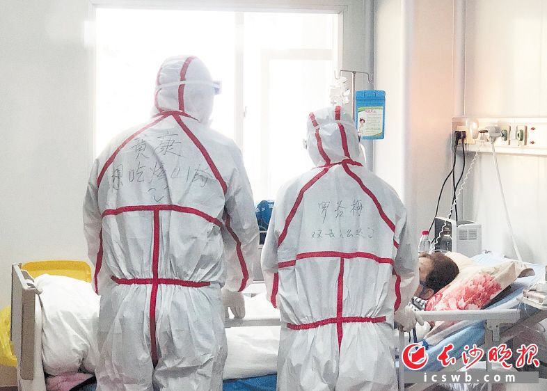 医护人员在长沙市公共卫生救治中心隔离病房查看病人情况。市一医院供图