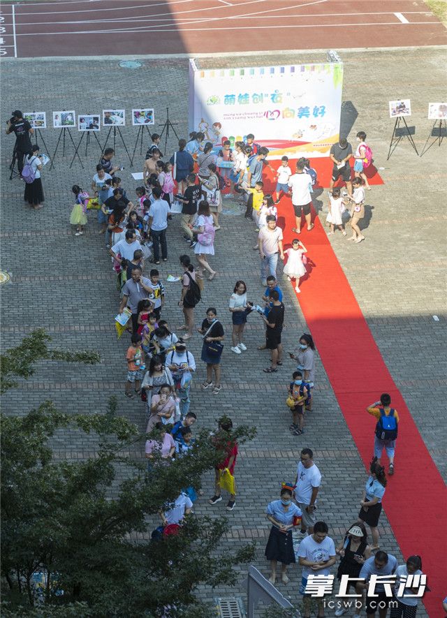 二至六年级的同学纷纷穿着自己设计的主题文化衫在背景墙前合影留念。