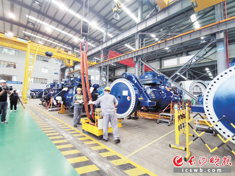 在中车株洲所风电事业部生产车间，一台台风电机舱整齐摆放着，工人们正在加班加点赶订单。