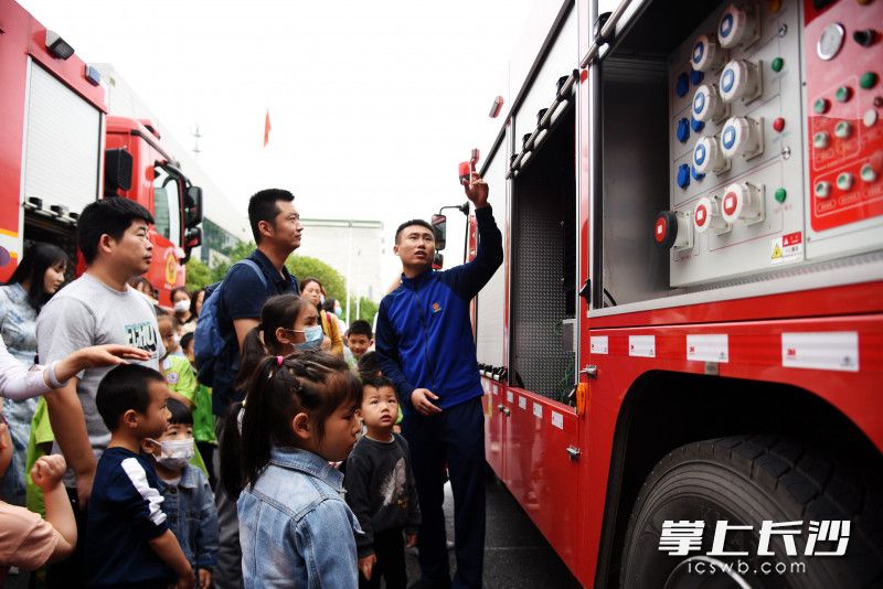 罗家坡消防救援站消防员为家长和消防小学员讲解消防车上的装备。