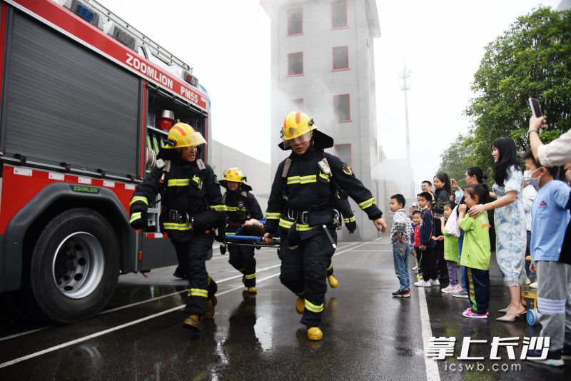 在消防演练中，消防员用担架快速将“被困人员”救出“火场”。