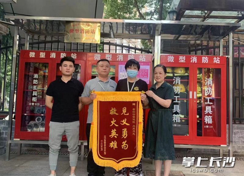 小区业委会给向庆（左二）送来锦旗。开福应急 供图