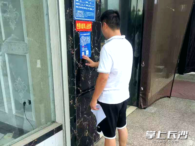 工作人员张贴安全生产问题隐患举报有奖的宣传单。