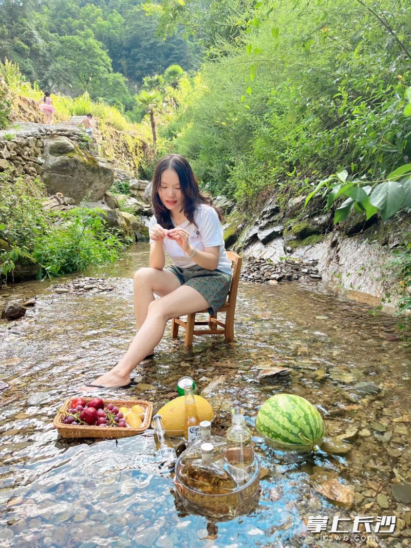 避暑客在沩山冰凉的山溪水里冷却西瓜和饮料。