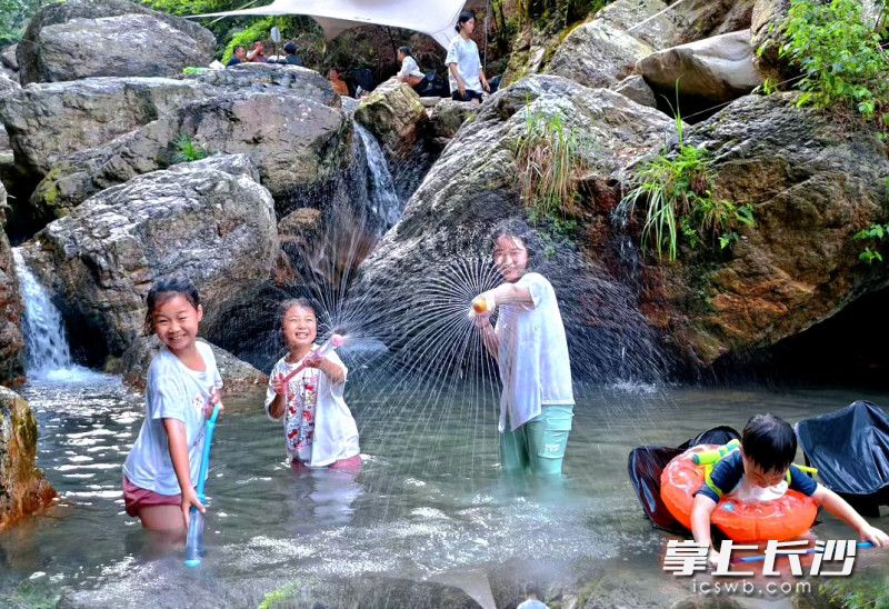 小朋友在沩山芦花瀑布边戏水消暑。均为长沙晚报全媒体记者 贺文兵 摄