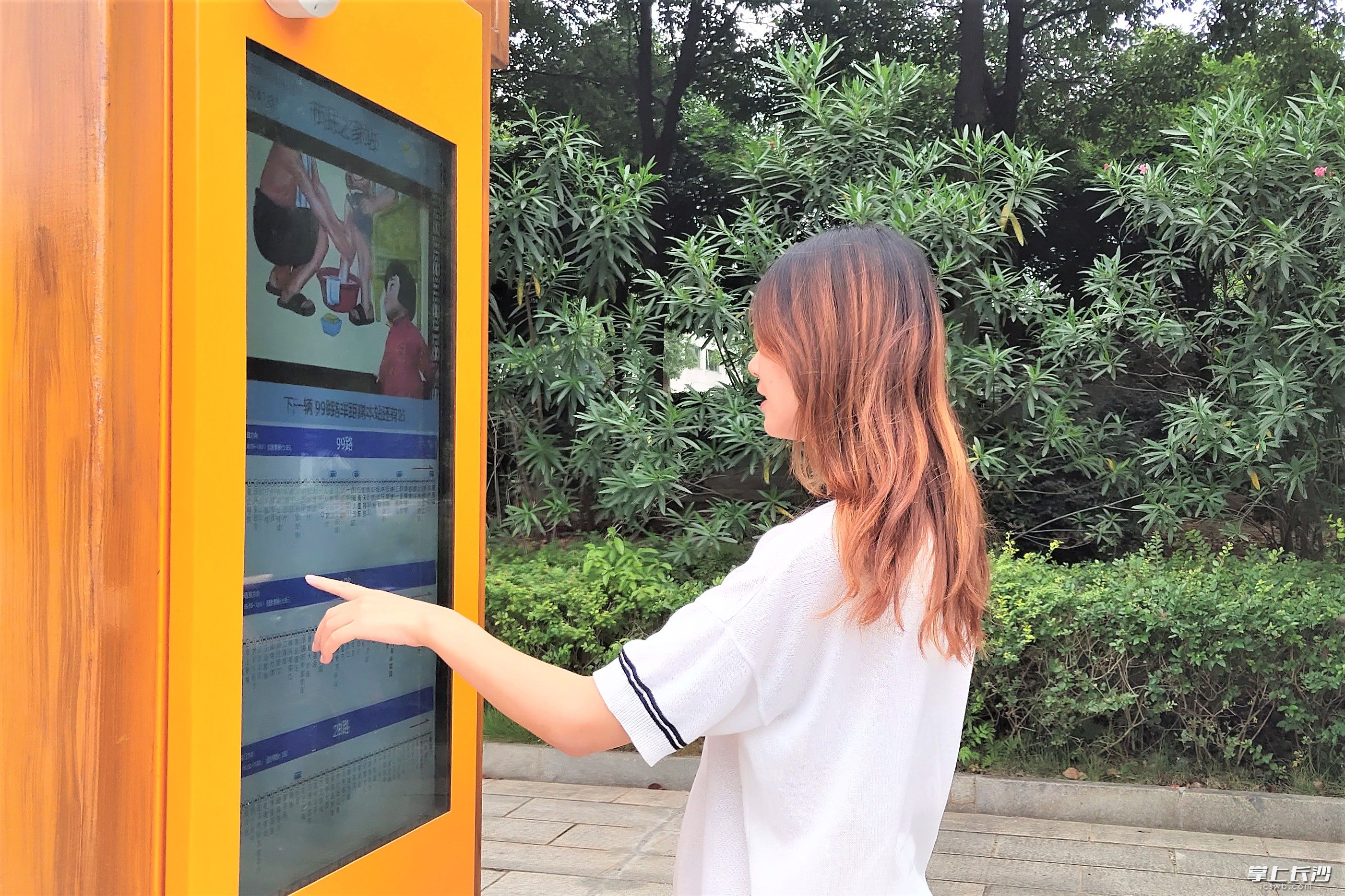 在宁乡市城区公交站，市民罗女士正在查看电子公交站牌，公交车到站信息一目了然。长沙晚报全媒体记者 张禹 摄