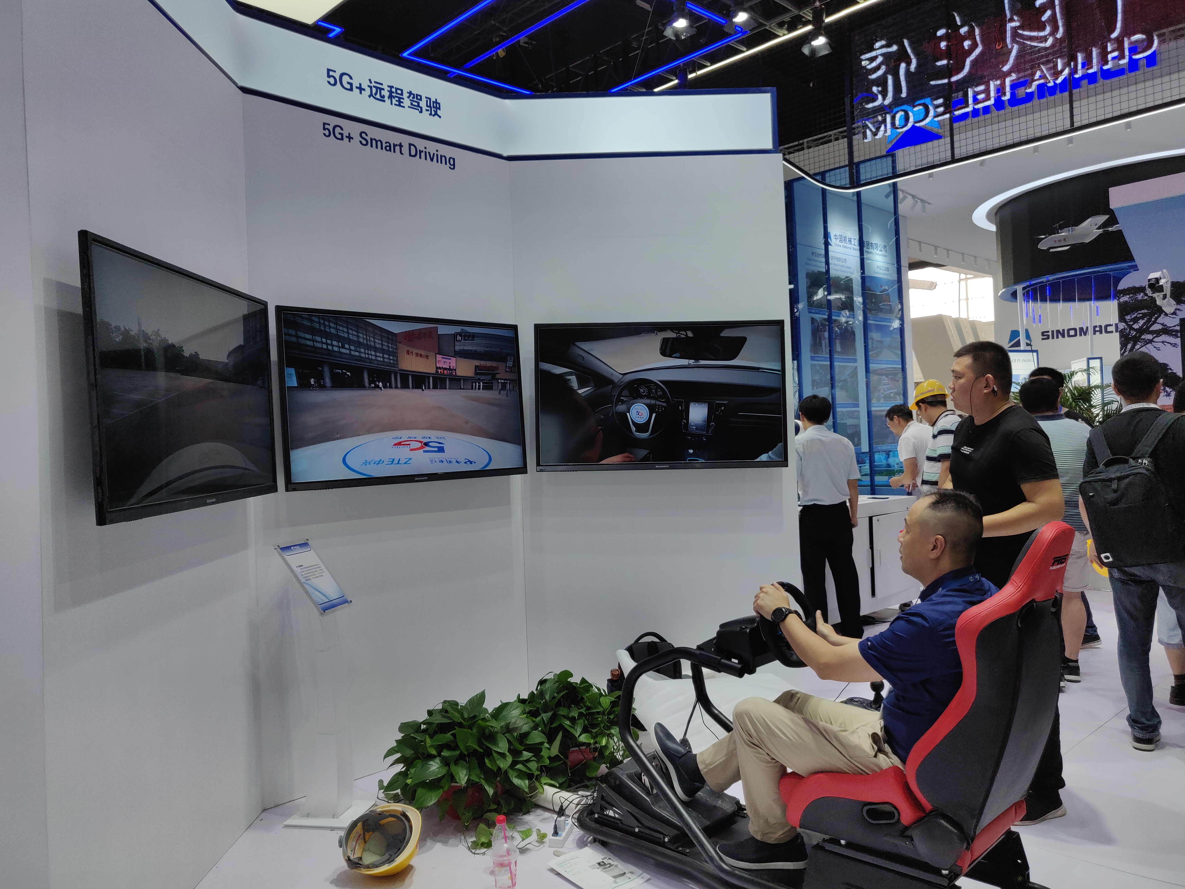 5g展区中的远程驾驶板块，一名中年人正在全神贯注地驾驶，遥控一辆新能源汽车。长沙晚报全媒体记者 王斌 摄