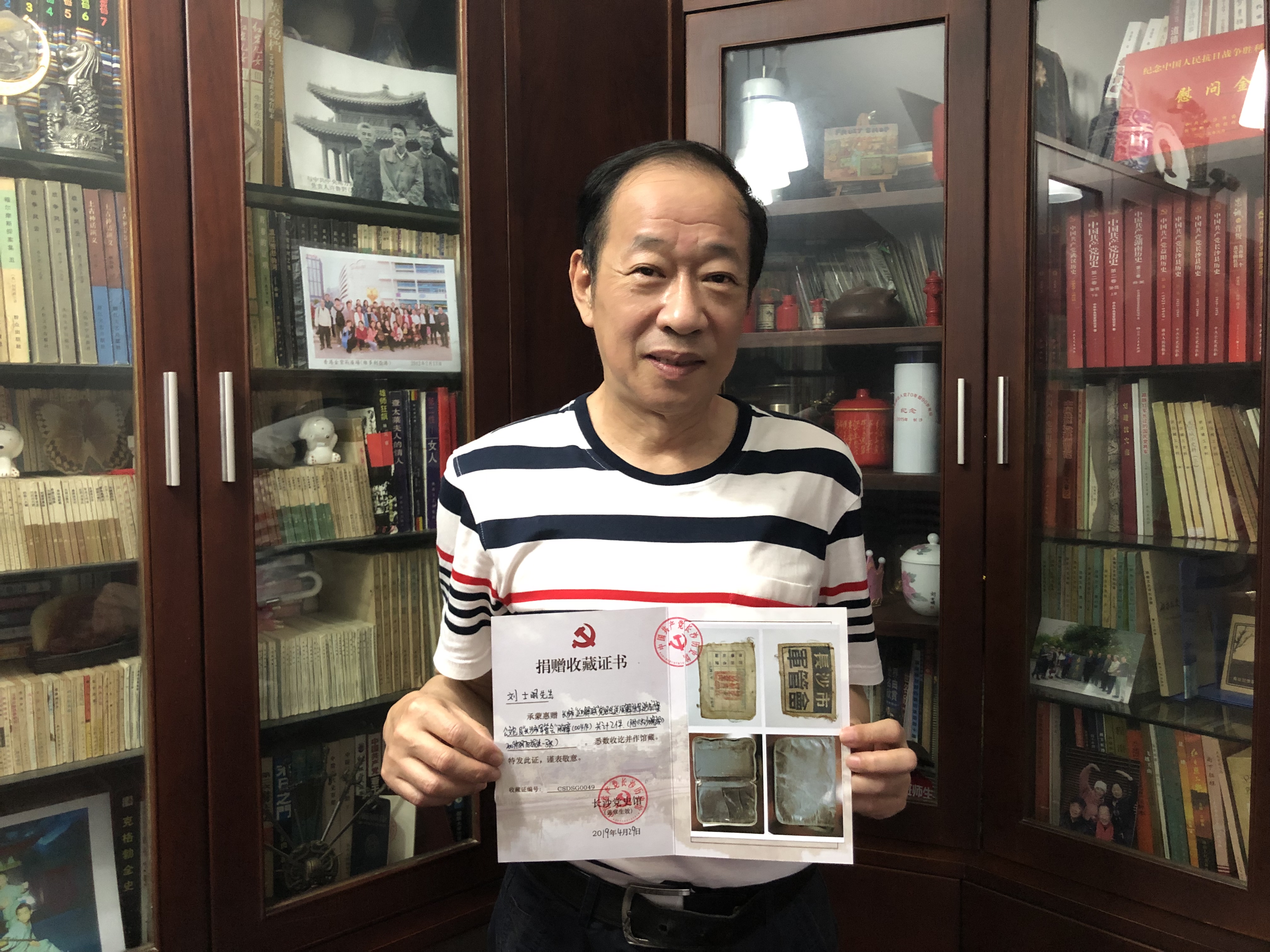 刘士明向记者展示长沙党史馆颁发的收藏证书。 长沙晚报全媒体记者 周游 摄 刘士明向记者展示长沙党史馆颁发的收藏证书。 长沙晚报全媒体记者 周游 摄