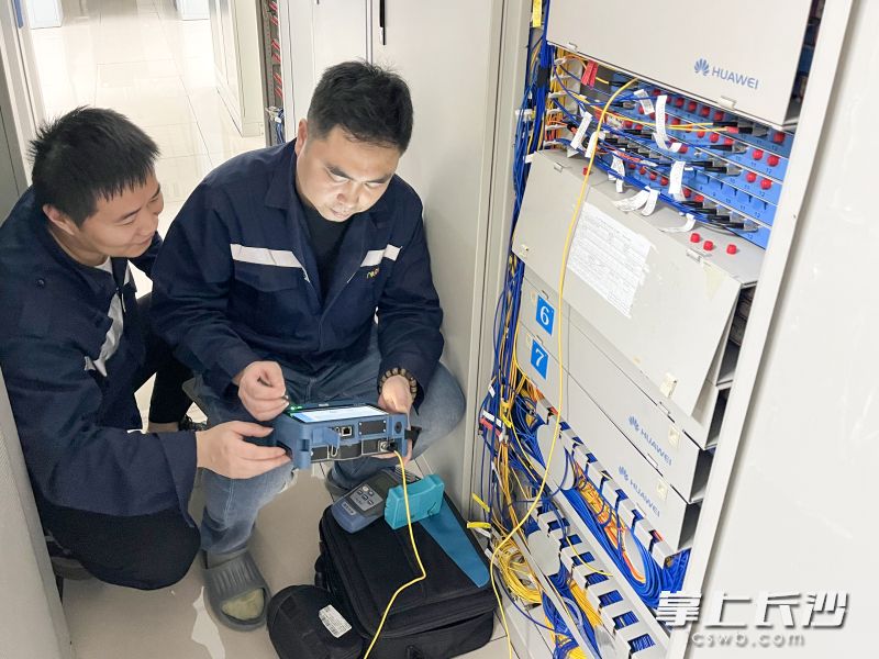 张常龙（右一）和同事在进行光缆应急处置