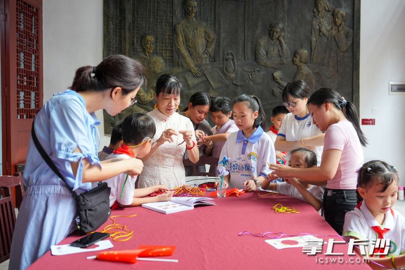 中国结绳编织技艺代表性传承人陈妙华（左三）带领大家体验传统手工艺的魅力。