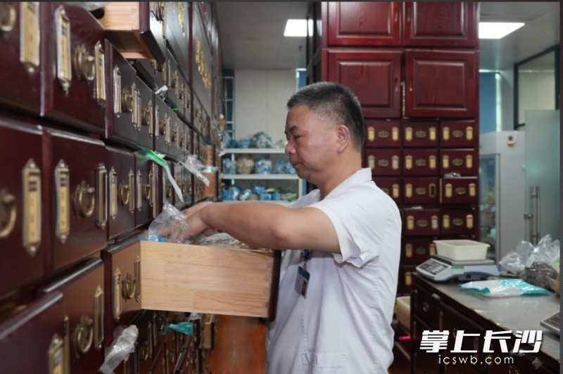 中药房的药师在忙于为病人抓药。