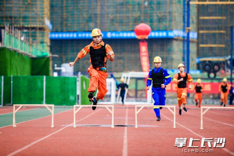 参赛队员跨越障碍，快速奔跑。