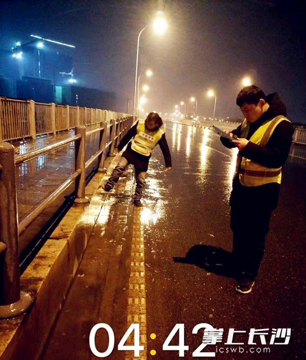 芙蓉环卫工作人员在查看桥面冰冻实况。